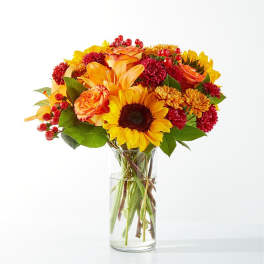 Bouquet of yellow and orange flowers in a clear glass vase