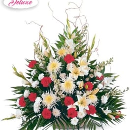 Large red, white, and yellow floral arrangement with tropical leaves
