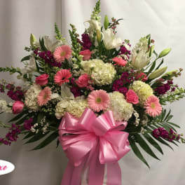 Pink and white mixed flower arrangement with a large pink bow