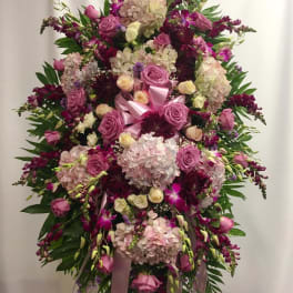 Large pink and purple floral standing spray with ribbon accents