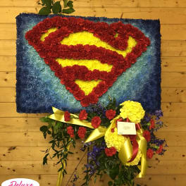 Superman logo made from red and yellow flowers on a blue floral panel