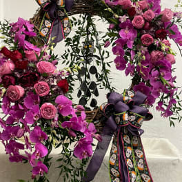 Purple orchid and pink rose wreath with skull ribbons