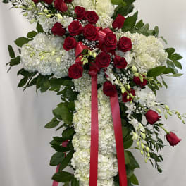 Standing floral spray with red roses and white hydrangeas on a ribboned easel