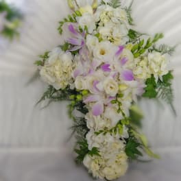 White floral cross-shaped arrangement with pale purple accents