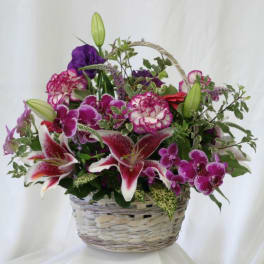 Basket arrangement with pink and purple flowers and lilies