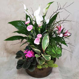 Mixed floral arrangement in a brown bowl with pink and white blooms