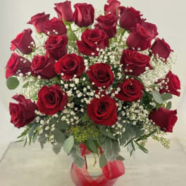 Bouquet of red roses with baby's breath in a clear vase