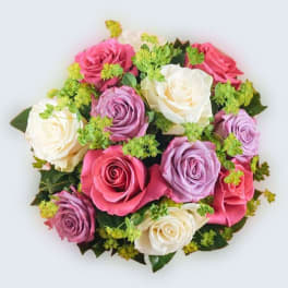 Round bouquet of pink, lavender, and ivory roses with small green filler flowers