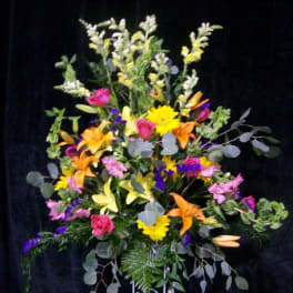 Tall mixed flower arrangement with lilies, roses, and daisies