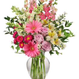 Pink and white mixed flowers arranged in a clear glass vase