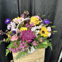 Mixed flower basket with yellow roses, sunflowers, and purple blooms