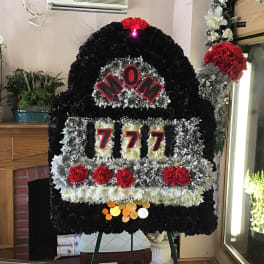 Large floral tribute shaped like a slot machine with red and black flowers