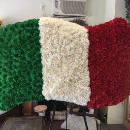 Floral display in green, white, and red arranged like a flag on an easel