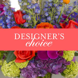 Colorful mixed flower arrangement with "designer's choice" text across the center