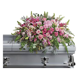 Pink floral casket spray on a silver casket