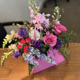 Pink and purple mixed bouquet in a pink gift box with a patterned ribbon