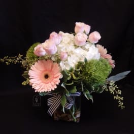 Pink roses and a white hydrangea arrangement in a glass vase