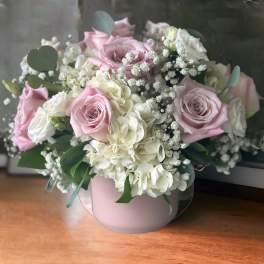 Pink and white rose bouquet in a round blush vase