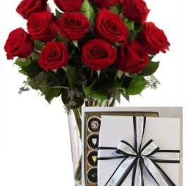 Bouquet of red roses in a clear vase with a box of chocolates