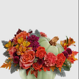 Fall floral arrangement in a pale green pumpkin container