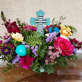 Colorful floral arrangement with a turquoise cross centerpiece