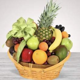 Fruit basket with pineapple, bananas, grapes, and assorted fruit in a wicker basket