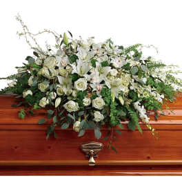 White floral spray on a wooden casket