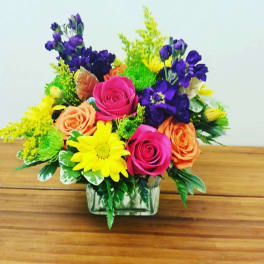 Colorful bouquet of roses and daisies in a glass vase