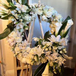 Large white floral wreath on a wooden easel