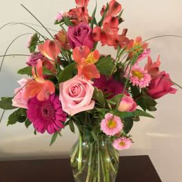 Pink and coral mixed bouquet in a clear glass vase