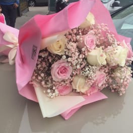 Pink and cream rose bouquet wrapped in pink paper