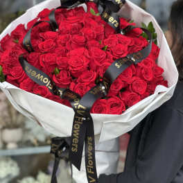 Large bouquet of red roses wrapped in white paper with black ribbon