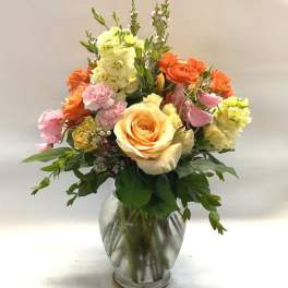 Mixed bouquet of roses and carnations in a clear glass vase