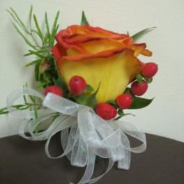 Single yellow-orange rose with red berries and white ribbon
