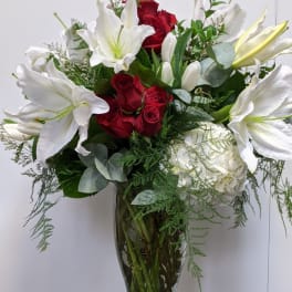Red roses and white lilies in a clear glass vase