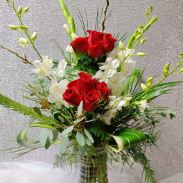Red roses and white orchids in a clear glass vase