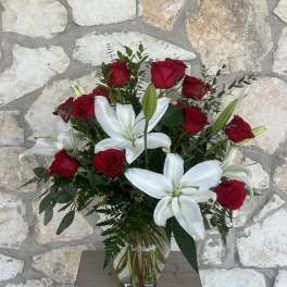 Red roses and white lilies in a clear glass vase
