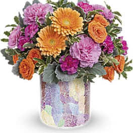 Mixed bouquet of orange, pink, and purple flowers in a mosaic vase