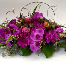 Purple orchid arrangement with apples and arched twigs