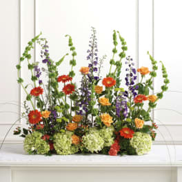 Tall mixed flower arrangement with orange and purple blooms