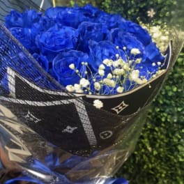 Bouquet of vivid blue roses with white baby's breath in black wrap