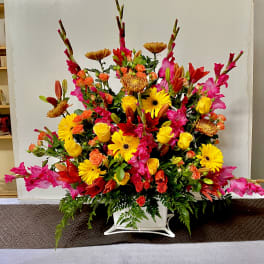 Large colorful floral arrangement in a white container