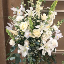 Tall white floral arrangement in a clear glass vase