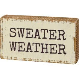Distressed wooden sign reading "SWEATER WEATHER"