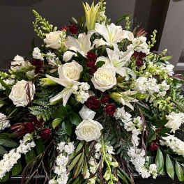 Large white and burgundy floral spray with lilies and roses