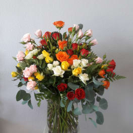 Mixed bouquet of roses in a clear glass vase