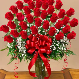 Bouquet of red roses in a glass vase with a red ribbon