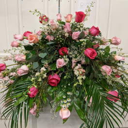 Large pink and red rose arrangement with cascading greenery