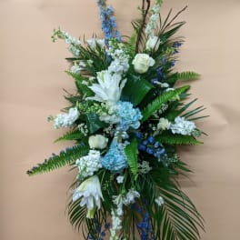 Tall floral spray with white and blue flowers on a stand