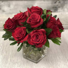 Red roses arranged in a clear glass vase